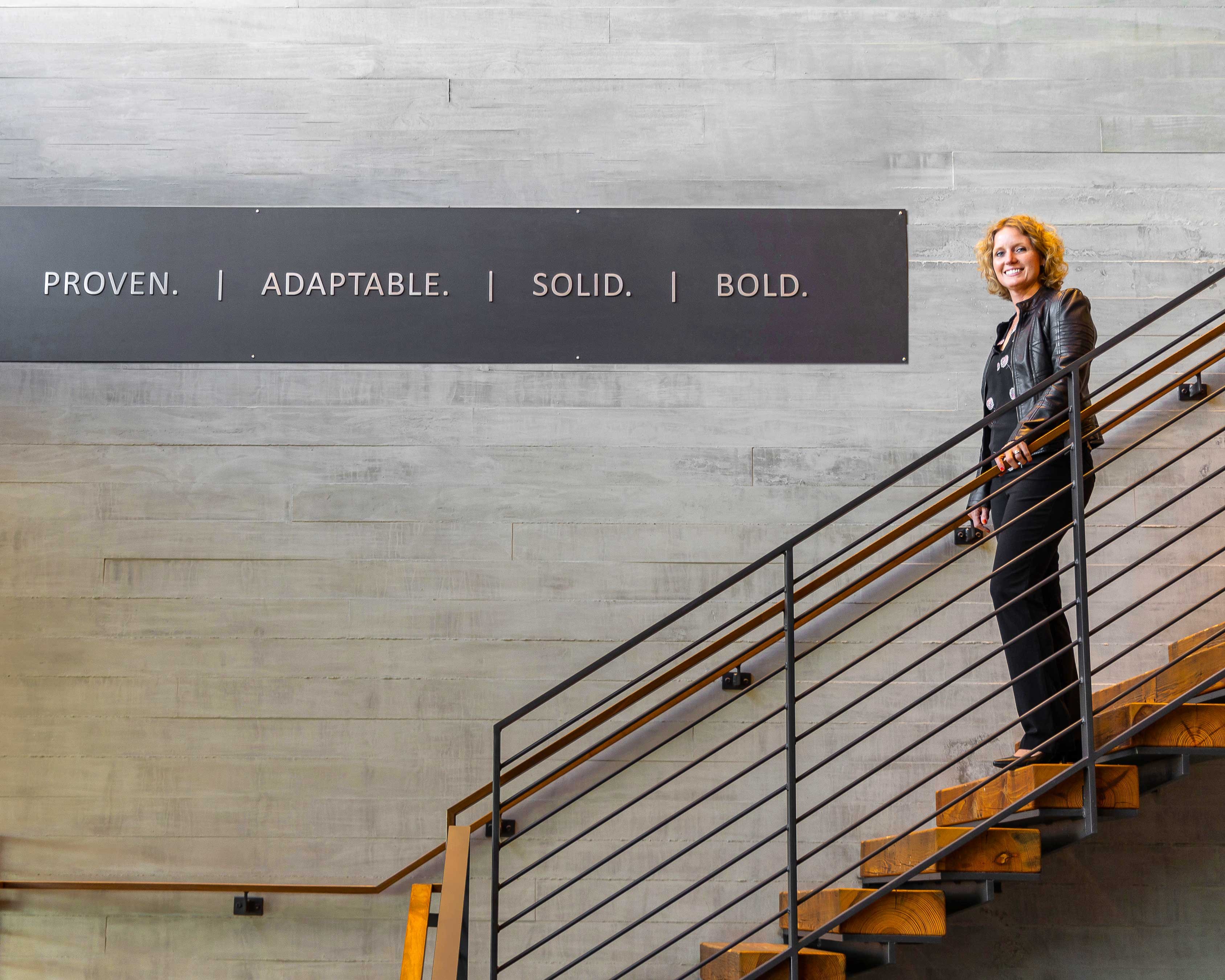 C.D. Smith Construction's VP of HR, Connie Coon, on the lobby stairs of the Fond du Lac, Wisconsin Corporate Office