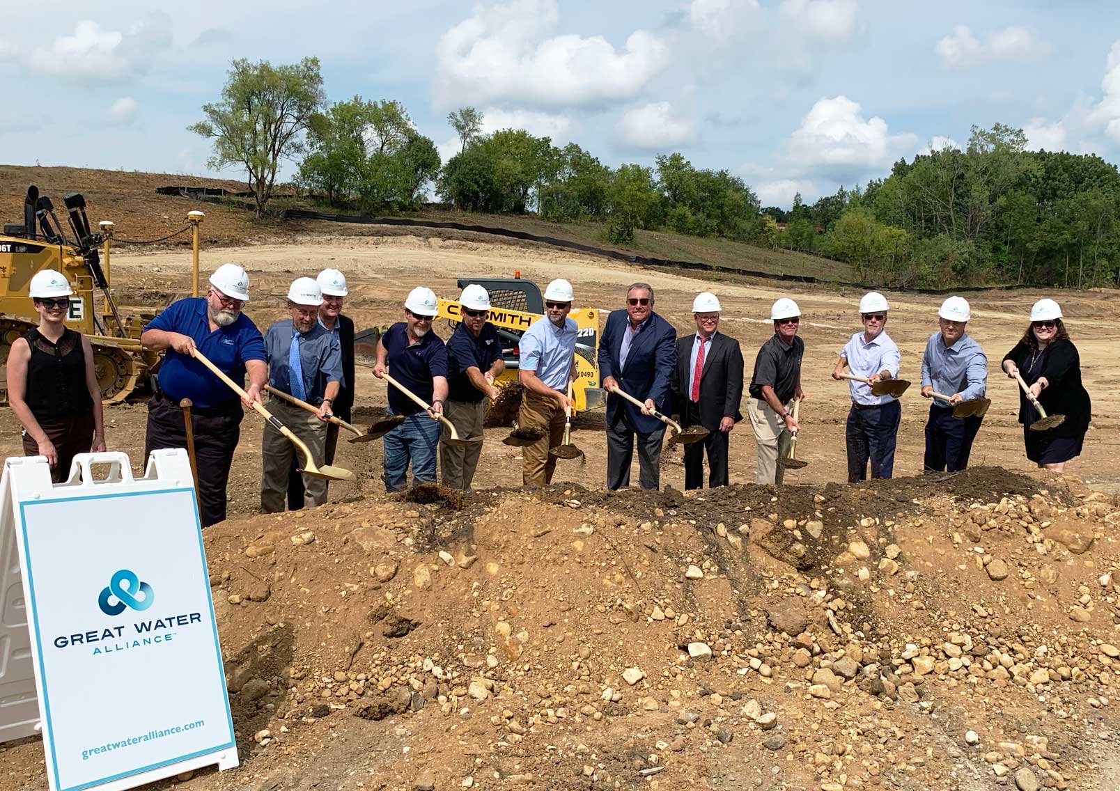 Government officials' shoveling dirt at groundbreaking event at Waukesha Booster Pumping Station site