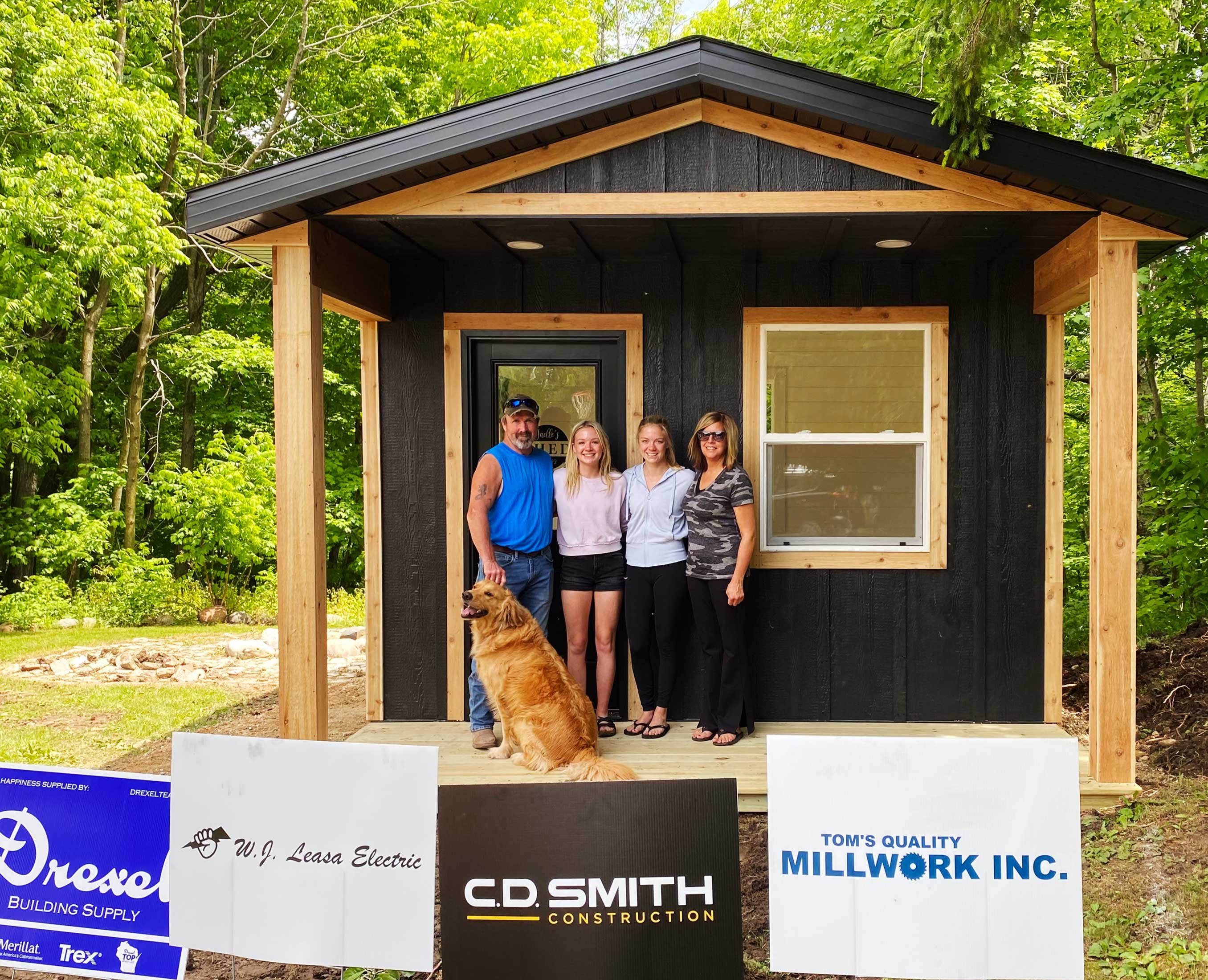 Make-A-Wish modern farmhouse She-Shed built by C.D. Smith Construction with the family standing in front.