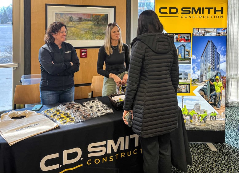 C.D. Smith Construction representatives speaking with students at the Women in Construction event sponsor booth