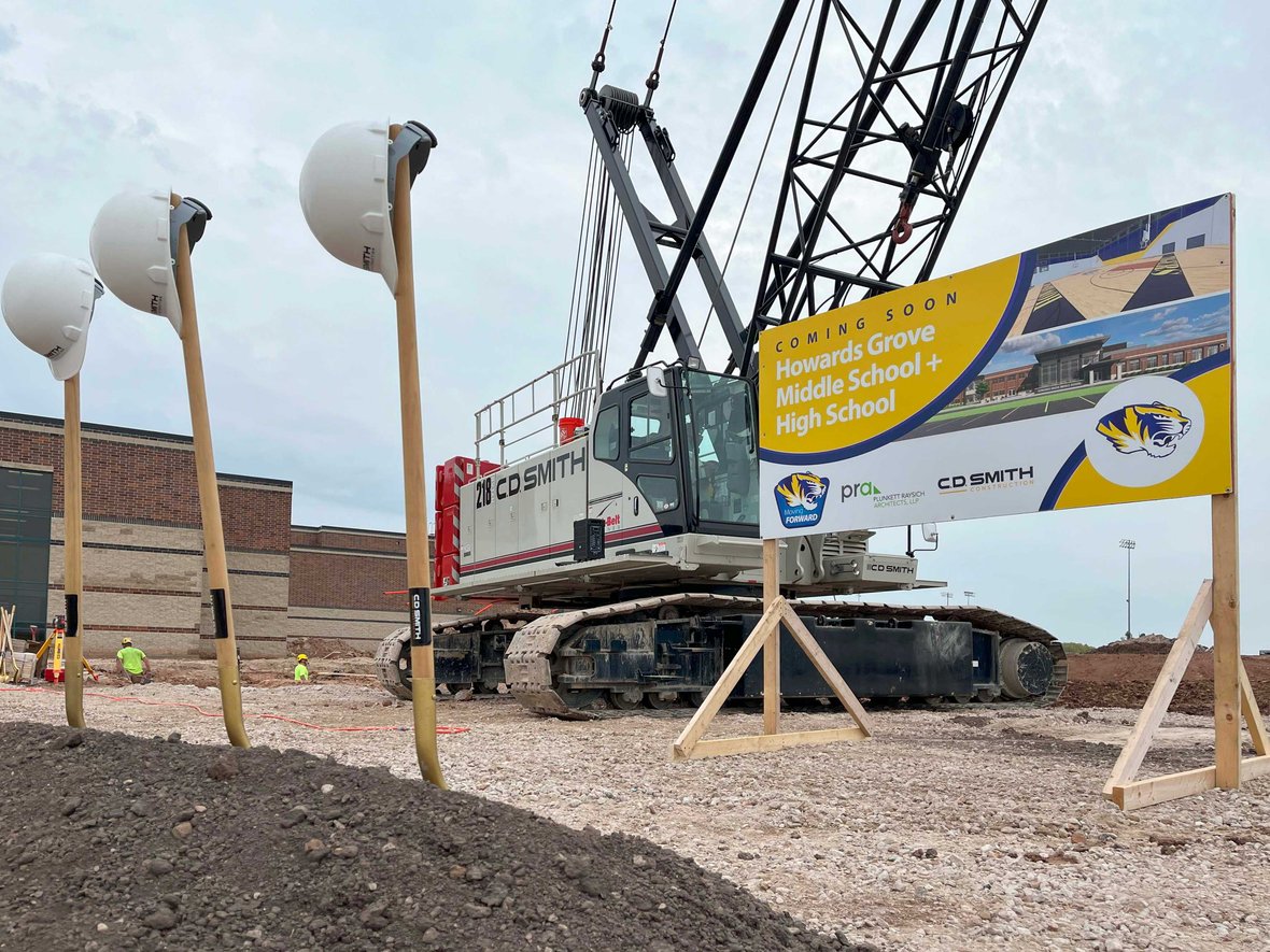 Shovels with project sign and CD Smith Construction crane in front of site of Howards Grove Middle-High School