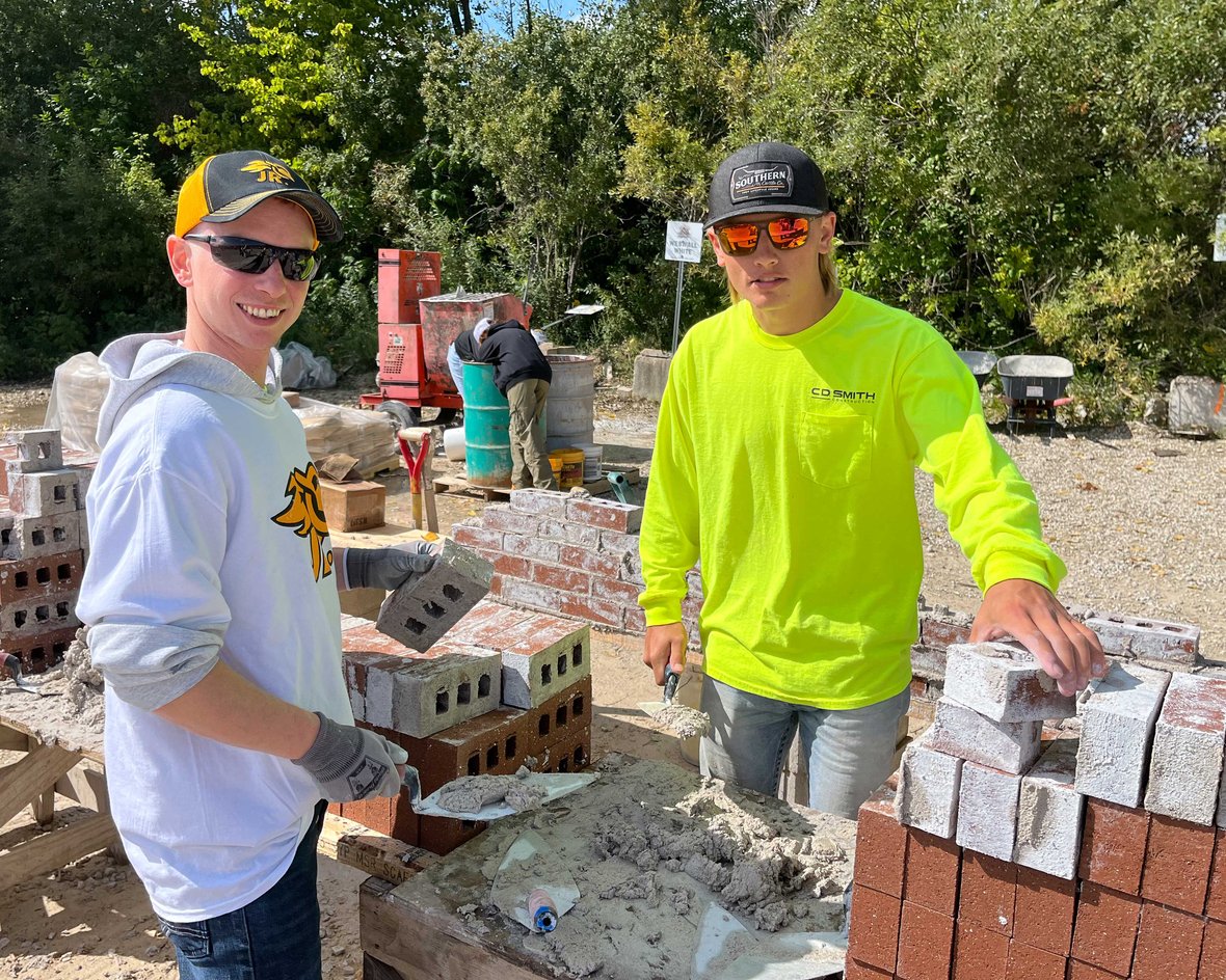 CD Smith Construction Team Member working with JR Bricklayer Student on masonry at Wisconsin Regional Competition