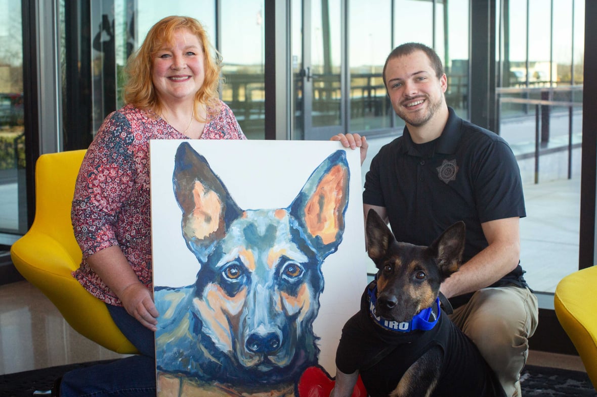 Artist Mindy Leitner, Deputy Evans, K9 Iro with painting at CD Smith Construction Fond du Lac WI Office