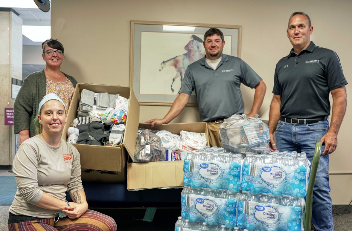 C.D. Smith Construction team with members of YWCA La Crosse and donated items for displaced local families in need.