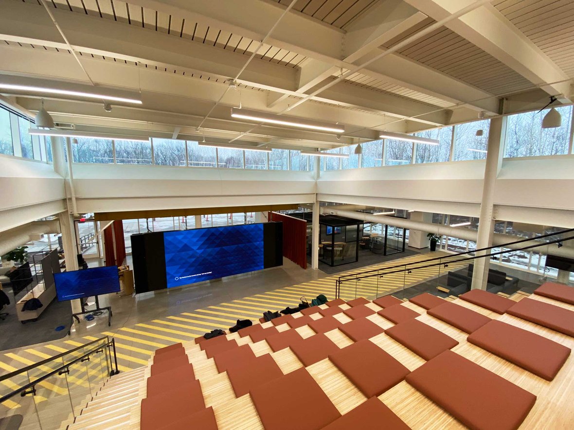 A collaborative workspace at the Schneider National Grove Innovation Center: The Grove Theater featuring a stage, seating, and a large LED display for presentations.