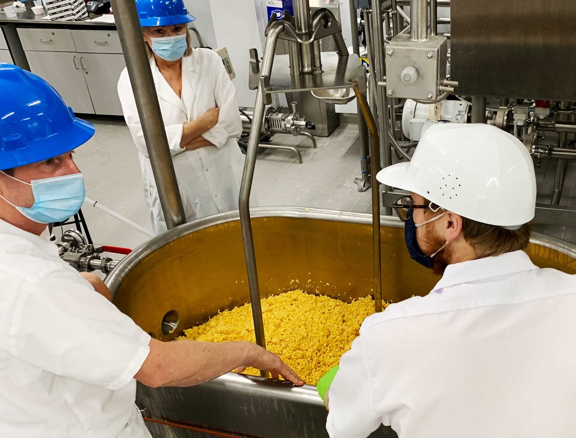 Three people making cheese at the Center for Dairy Research upon substantial completion by C.D. Smith Construction