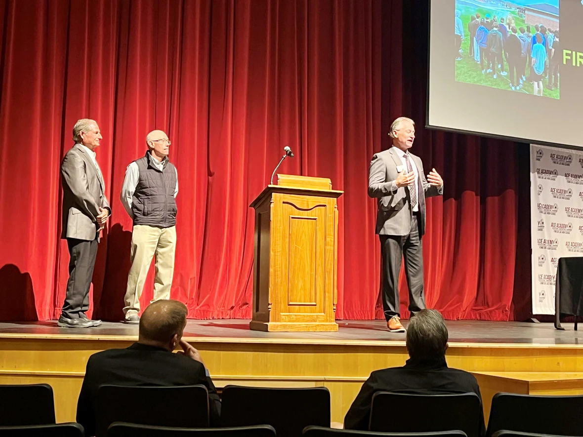 Bob Barker Executive Vice President of AGC and Vern Wilder ACE Academy Instructor recognize Bob Roehrig on high school stage for constributions to FDL ACE Academy in Wisconsin