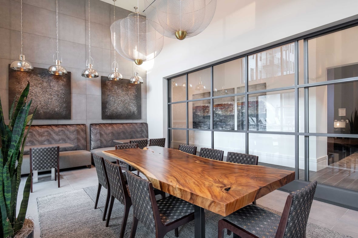 Glass wall community room with live edge table at Brickline at The Mercantile apartment building in Omaha Nebraska with CD Smith Construction Manager