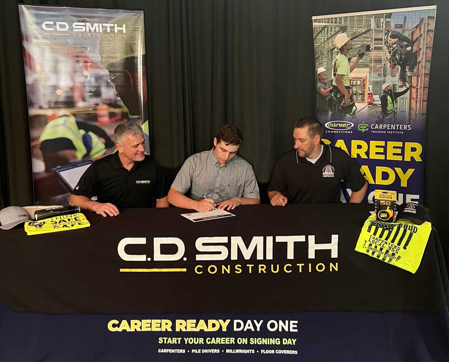 Signing day picture with Riley Zick being hired by C.D. Smith Construction while pursuing a carpentry apprenticeship