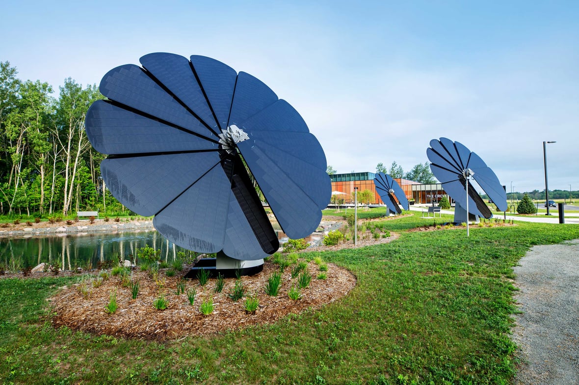 Solar panels shaped like flower petals collecting energy in front of sustainable new CD Smith Construction project building Schneider National's Grove Innovation Center