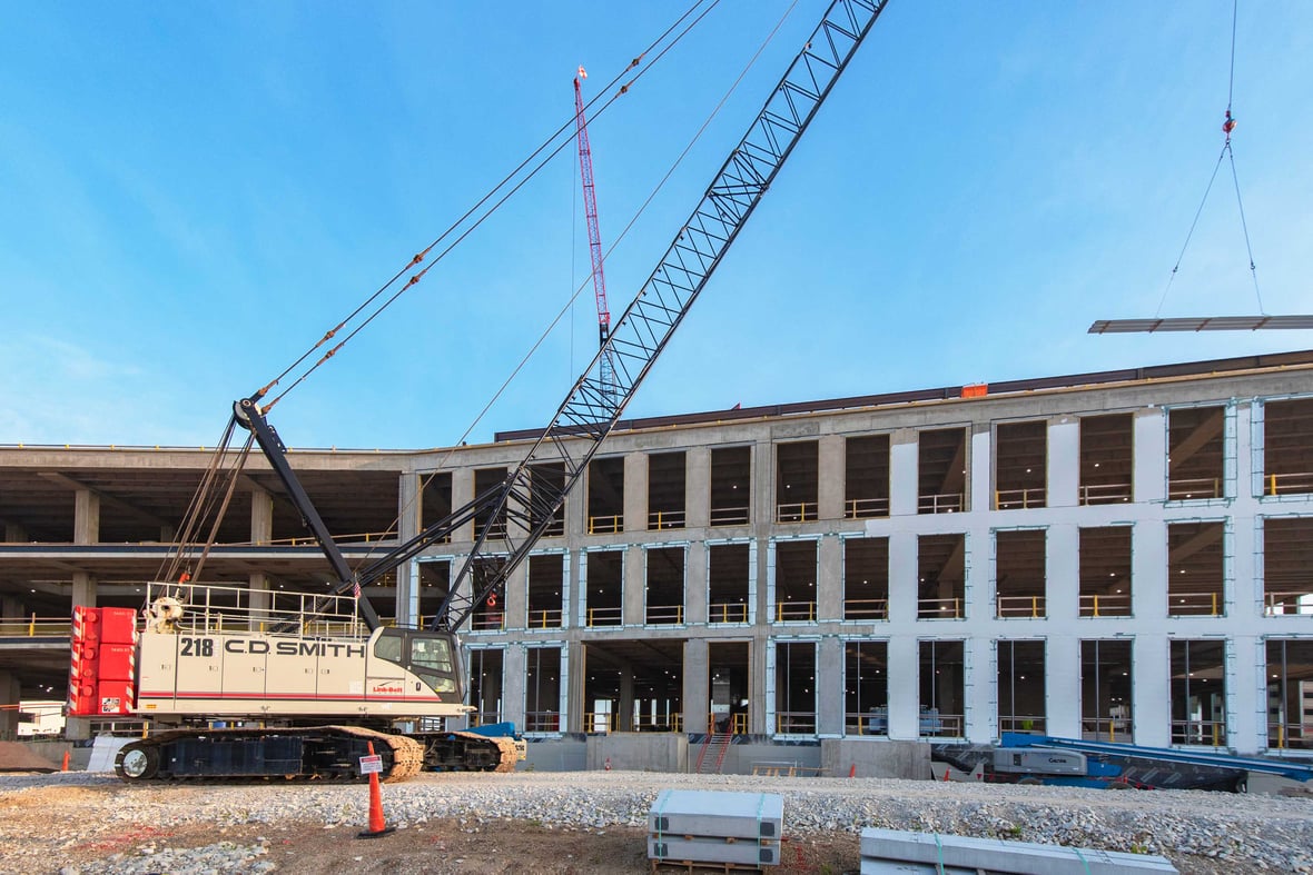Workers guide reinforced concrete into place for structural support at the Milwaukee Crime Lab site — a healthcare construction project underway in Southeast Wisconsin.