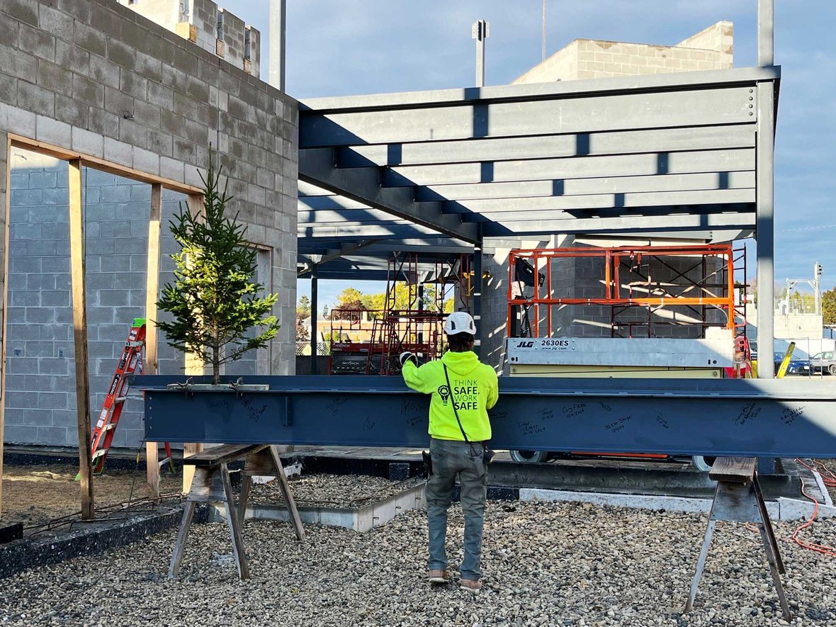 CD Smith Construction ironworker with steel beam for topping out Kewaskum Community Center project in Wisconsin