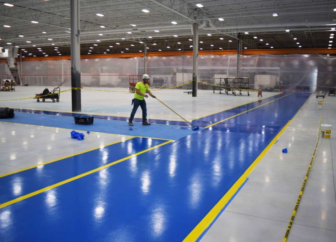 C.D. Smith construction workers finishing concrete floor interior at Kondex Corporation manufacturing addition project