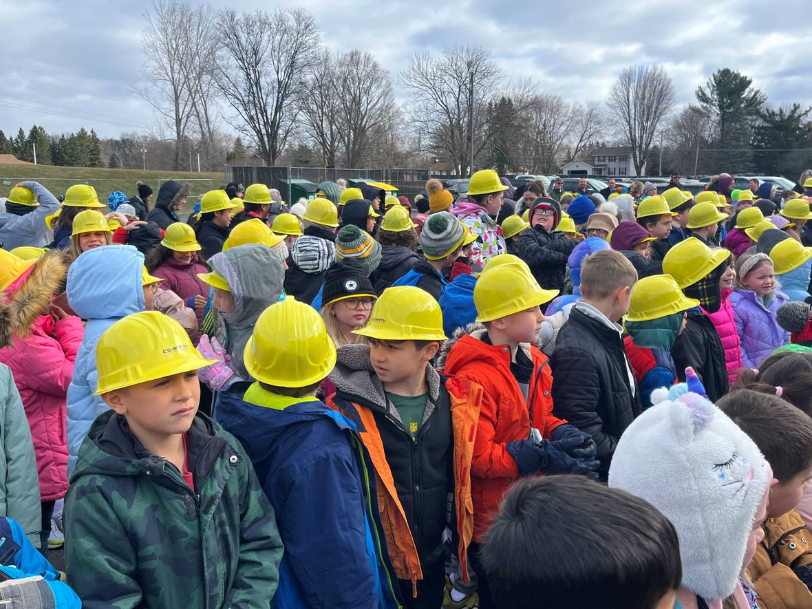 Students gather wearing CD Smith Construction hard hats at Pulaski Hillcrest Elementary School Project Groundbreaking