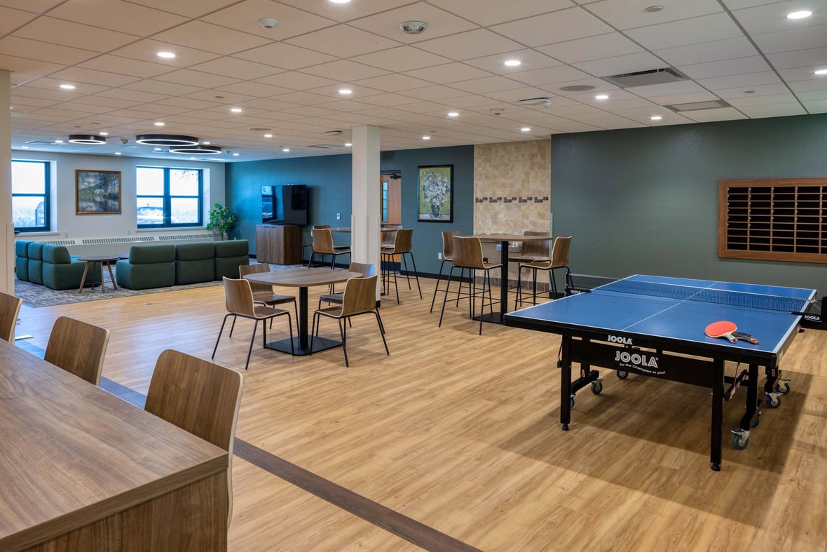 Interior view of the student commons at Fr. Solanus Hall with lounge seating, study tables, and a ping pong table.