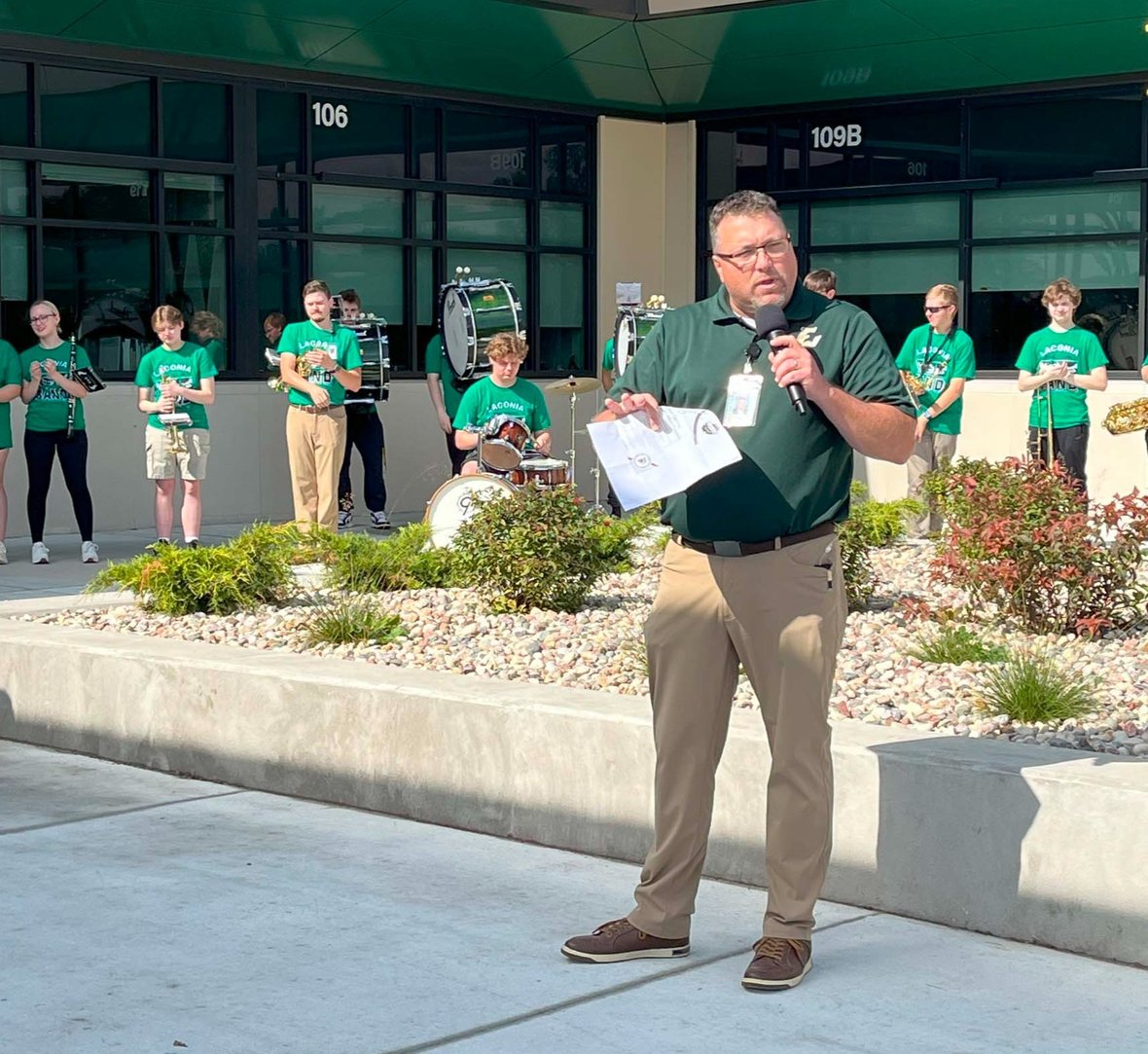 Rosendale-Brandon Superintendent addresses attendees outside Laconia High School with the pep band behind him during the ribbon-cutting ceremony.