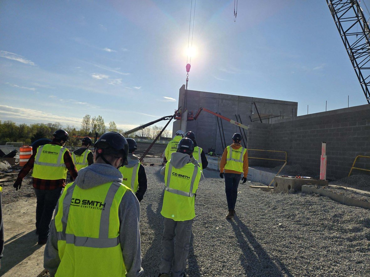Franklin High School Construction II students watching crane operations and wall panel installation on an active C.D. Smith construction project during a CDS School Partnership Program jobsite experience.
