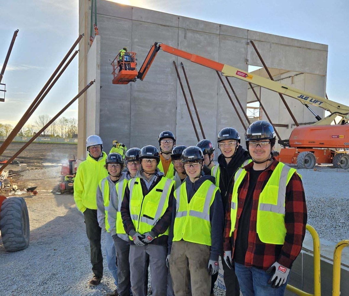 Franklin High School Construction II students and C.D. Smith construction team members on an active jobsite during a CDS School Partnership Program site visit featuring wall panel and crane operations.
