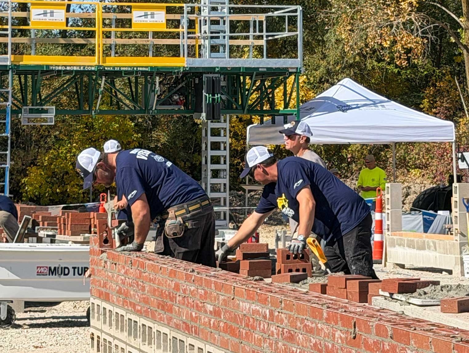 Mason and tender teams build brick walls during the 2026 SPEC MIX Bricklayer 500 Wisconsin Regional at Fond du Lac Natural Stone.