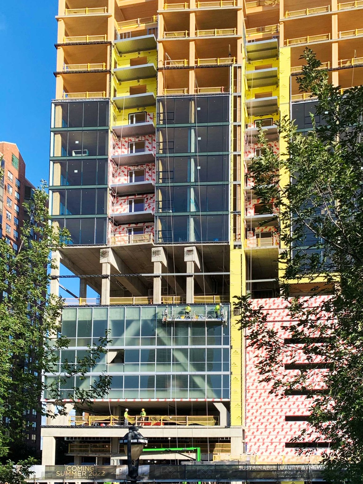 Instalação de envidraçamento e parede cortina nos andares inferiores da construção de edifícios de madeira maciça Ascent em Milwaukee