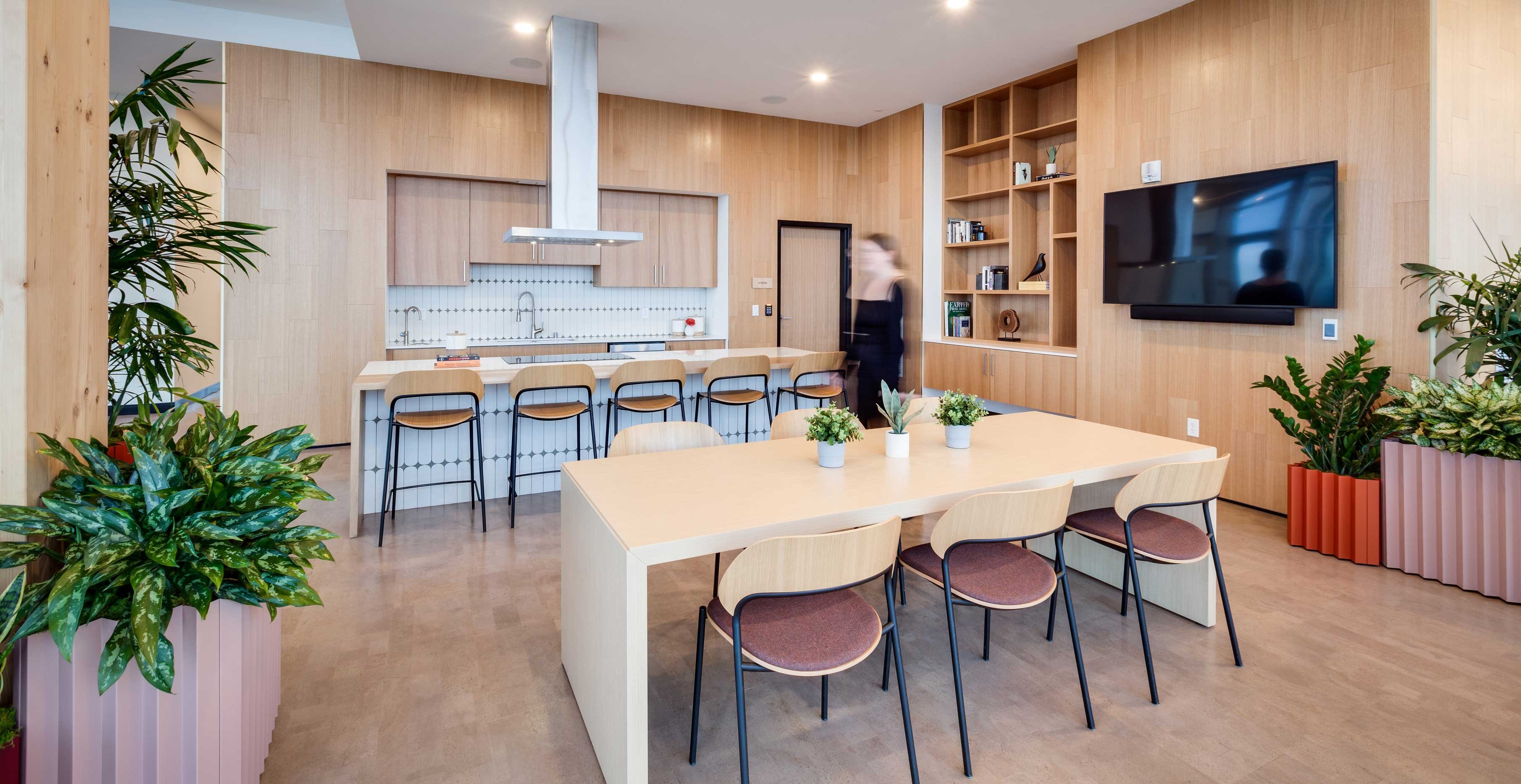 Community kitchen at Ascent Milwaukee with exposed timber framing, modern cabinetry, and city views.