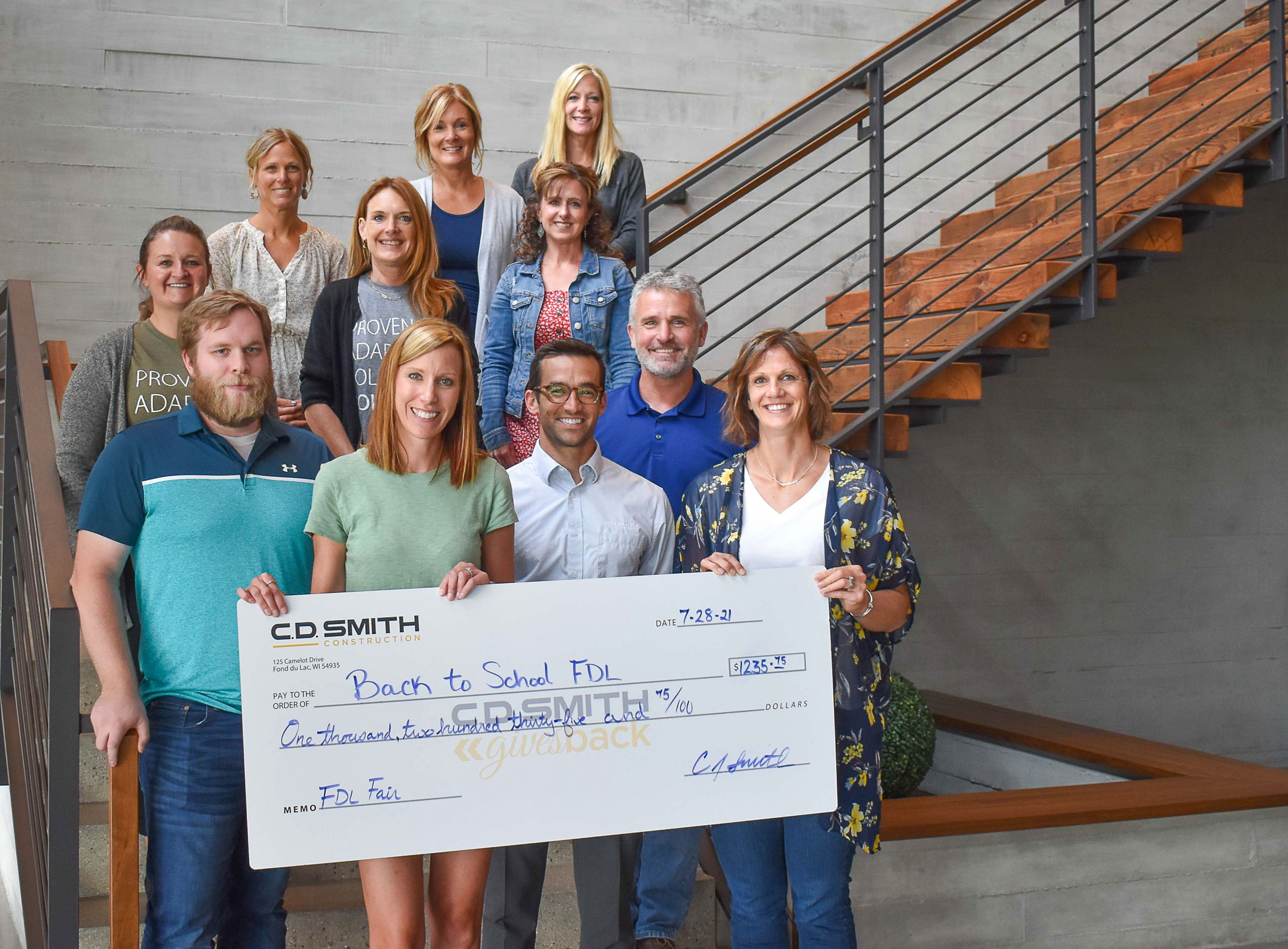 C.D. Smith Construction Gives Back volunteering at Fond du Lac County Fair & with check presentation from tips for the Back to School FDL Area program.