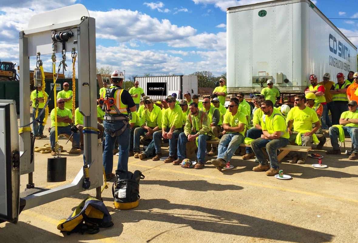 CD Smith Construction Fall Protection Safety Training with instructor wearing gear and audience of skilled trades building professionals in Wisconsin