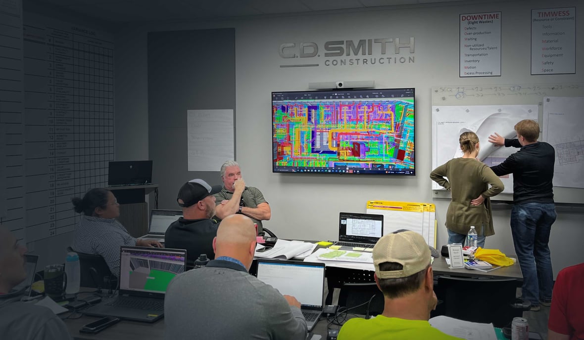 CD Smith Project Team at tables with Virtual Design & Construction drawings on screens in Pull Planning group session