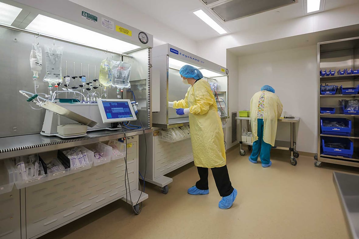 Healthcare professionals working inside a sterile compounding and prep room, illustrating precision planning and controlled environments in modern healthcare construction.