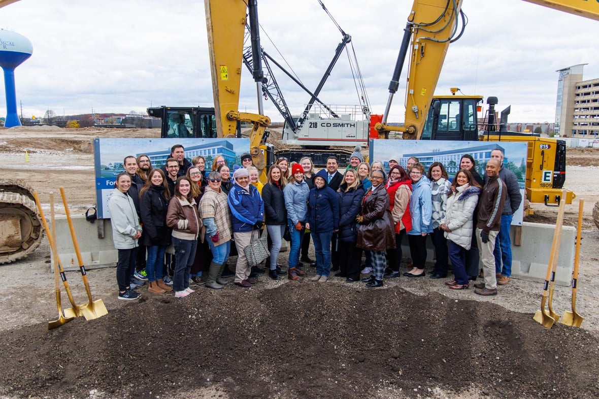 Large group standing by dirt and shovels at groundbreaking ceremony for the Forensic Science and Protective Medicine Facility project construction with CD Smith