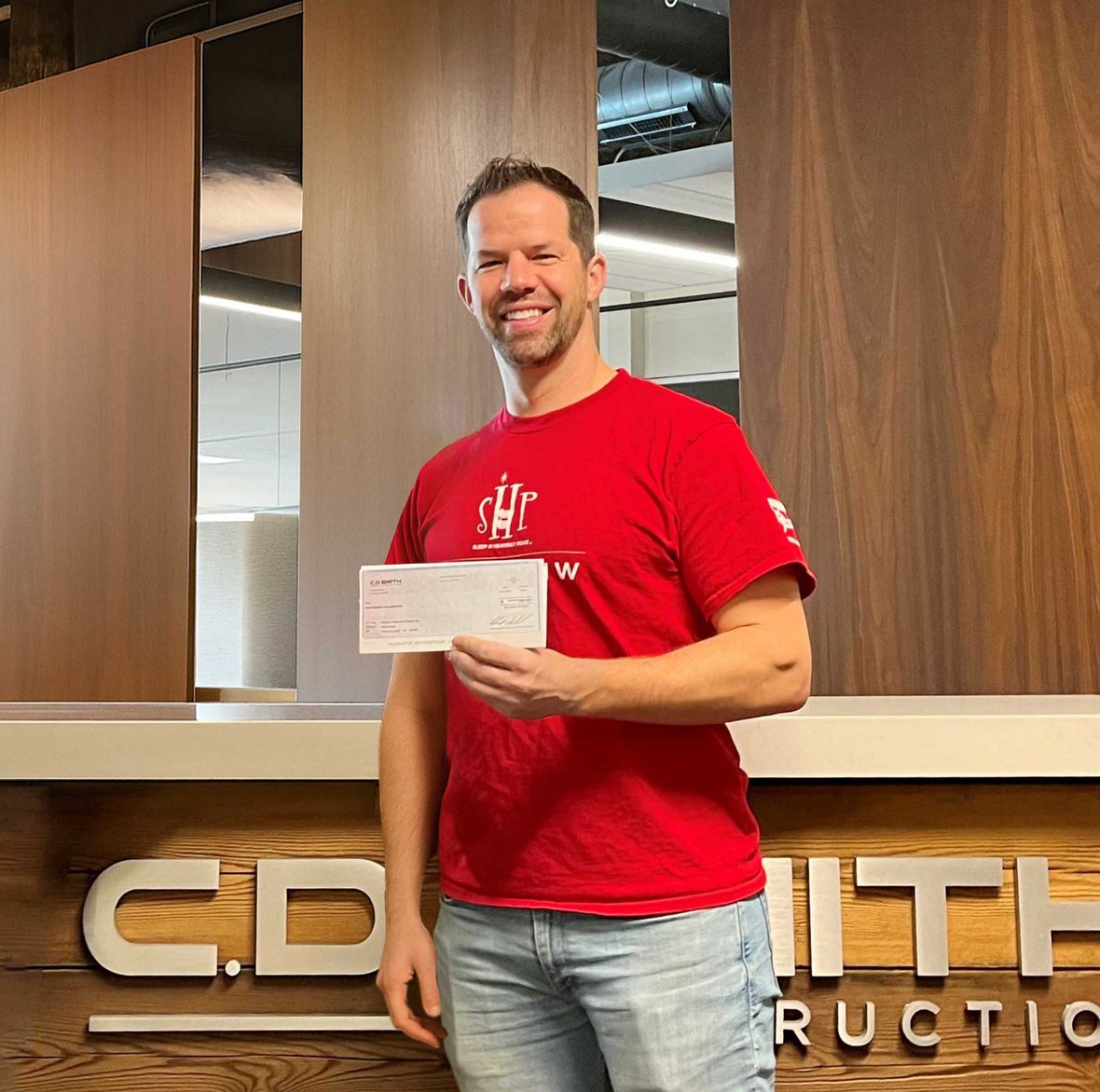 SHP WI-Madison Chapter President Casey Klock at C.D. Smith Construction's Madison Office with donation check