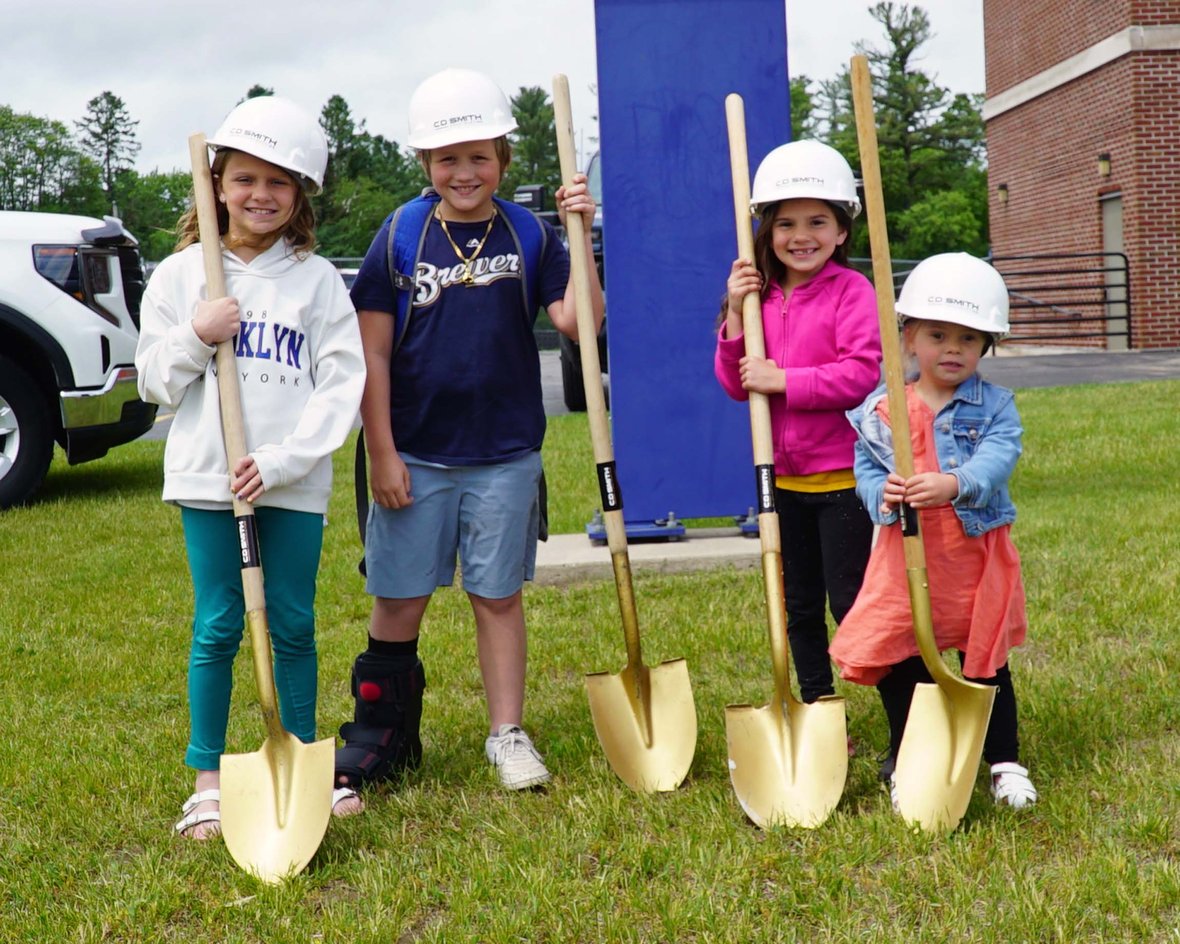 Young students from Crivitz Elementary in hard hats participating in the school’s construction groundbreaking ceremony