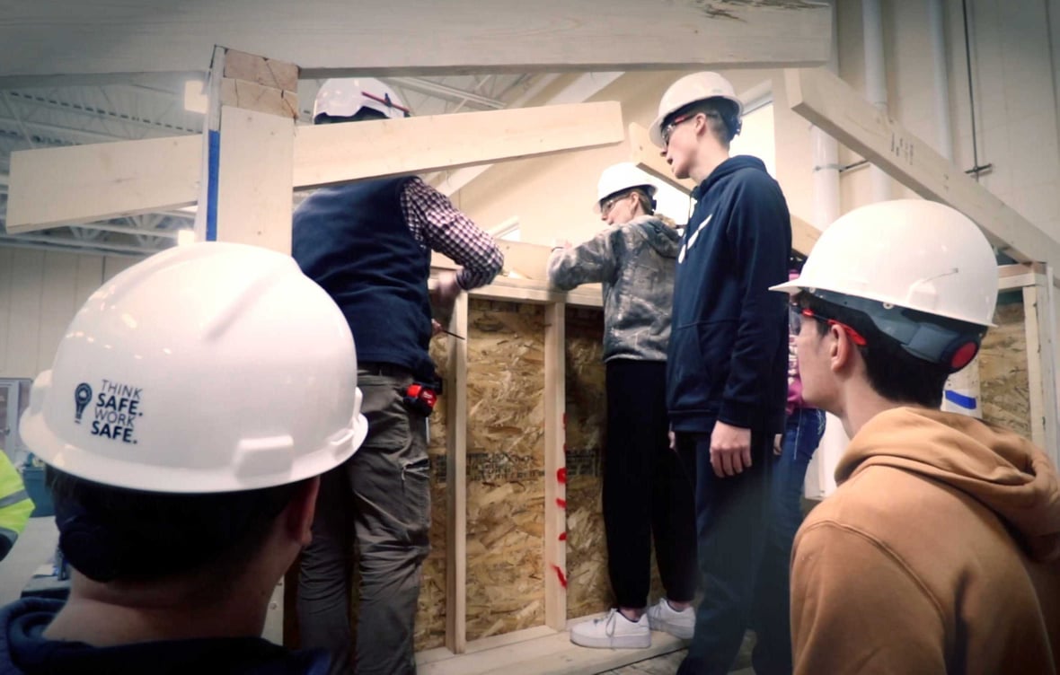 Students participating in hands-on construction training at ACE Academy in Fond du Lac, Wisconsin, learning framing techniques in a state-of-the-art classroom setting.