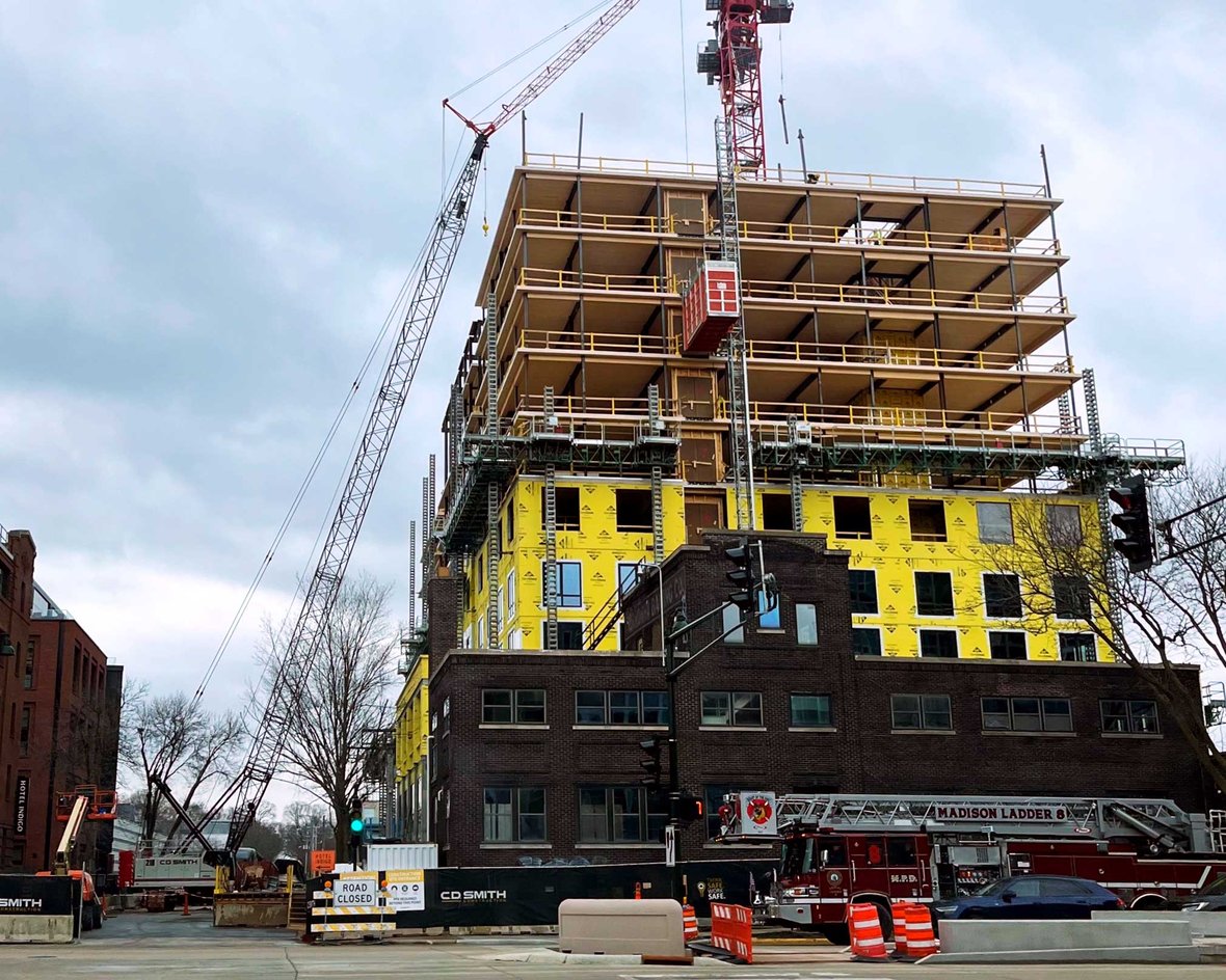Photo from street of Bakers Place Mass Timber Building Construction in Madison Wisconsin with CD Smith cranes and equipment on the project