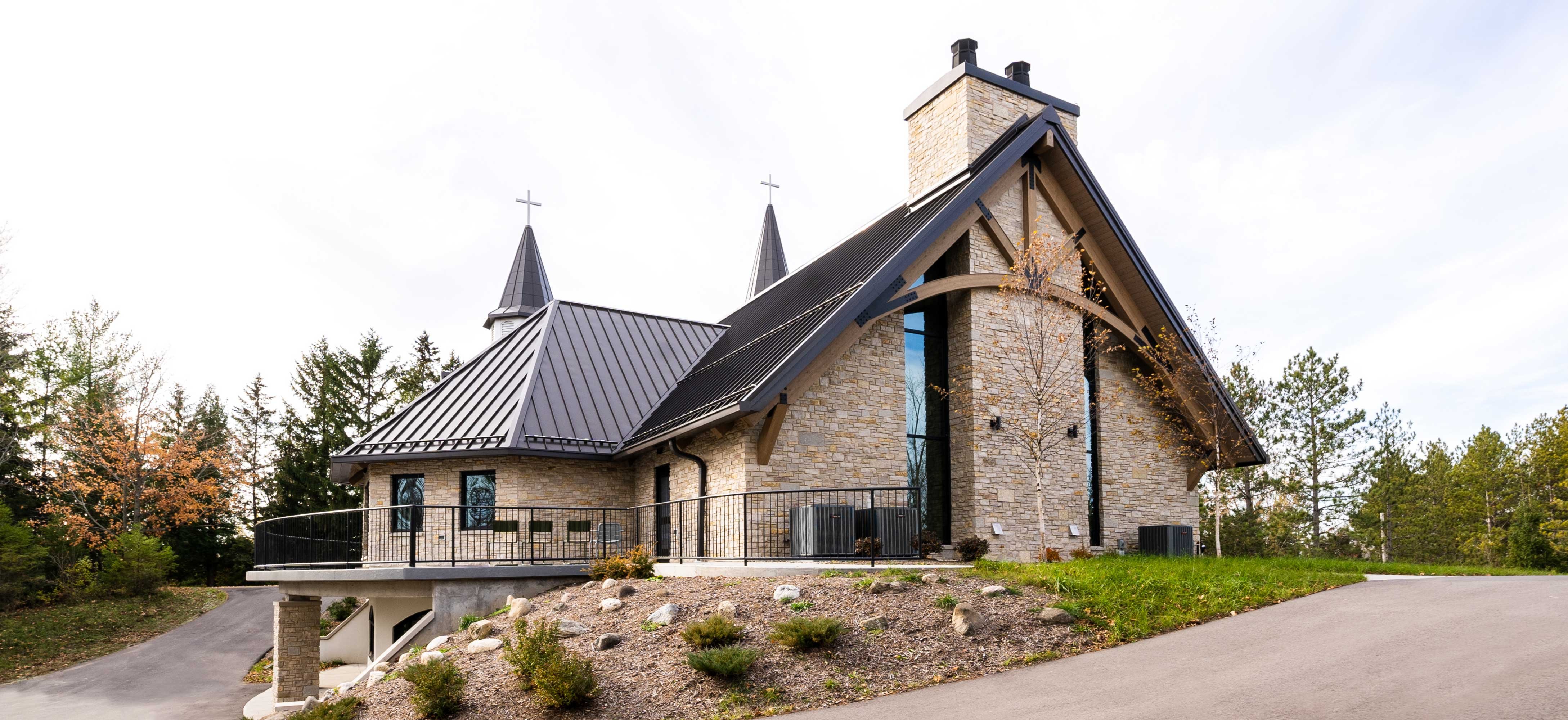 exterior view C.D. Smith Construction Manager for Camp Vista chapel project with wood beams, stone wall masonry and patio