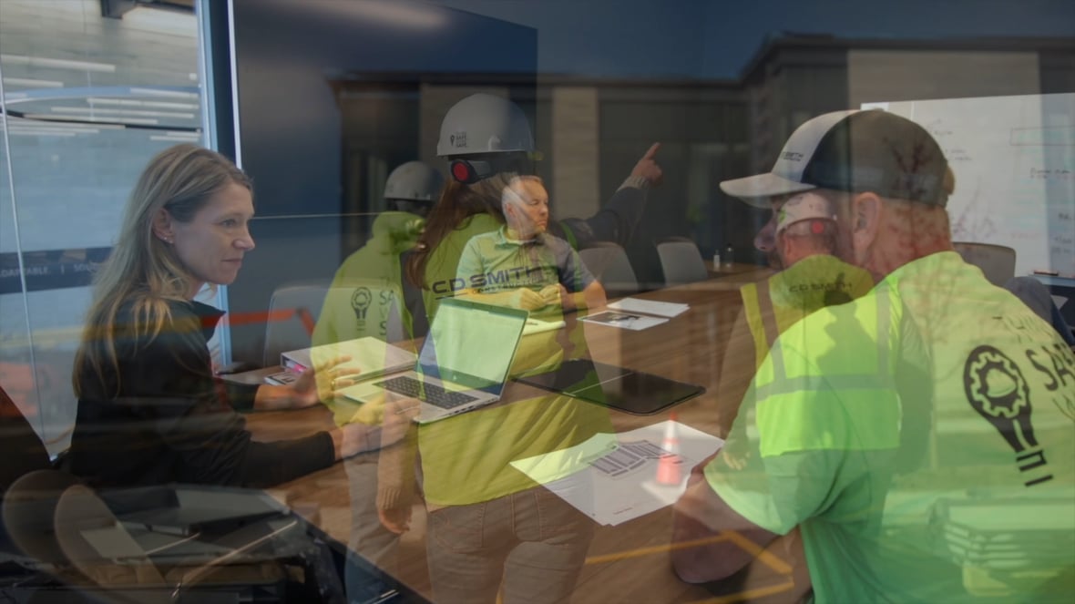 Screenshot from Healthcare Construction Video with Project Team Meeting at CD Smith Office fading to field crew approaching jobsite