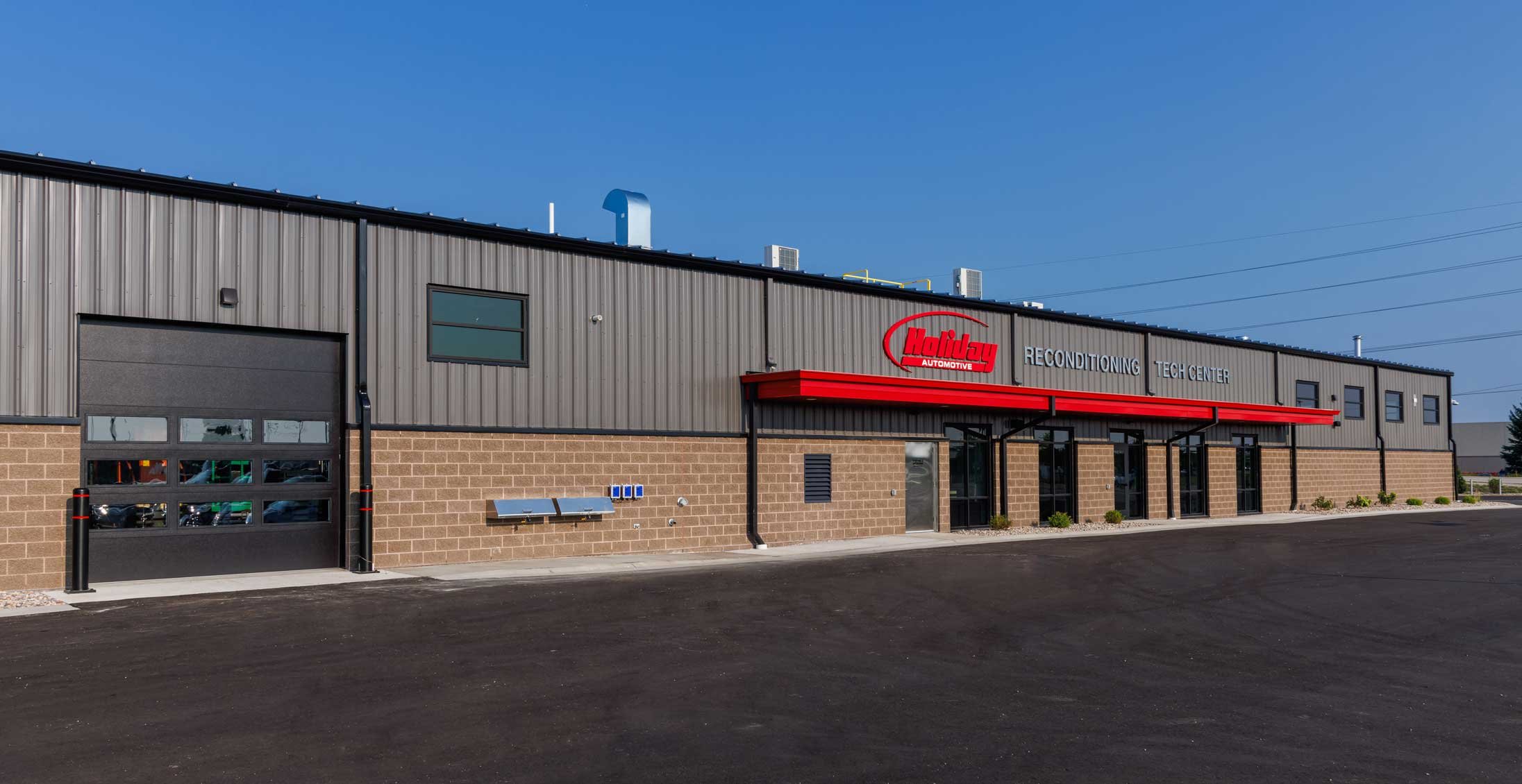 Exterior of Holiday Automotive Reconditioning & Technology Center constructed by C.D. Smith featuring service bay access and branded façade.