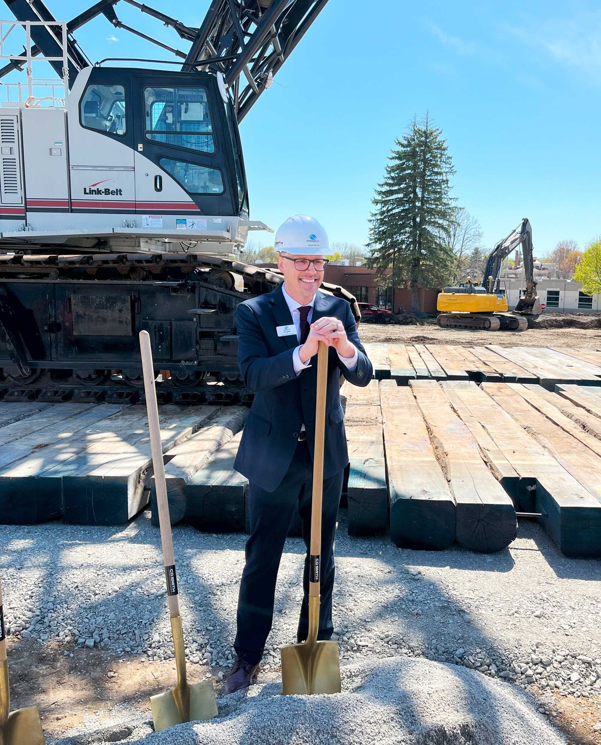 Jason Presto CEO Boys & Girls Club of the Tri County Area with shovel at groundbreaking for Ripon facility with CD Smith Construction crane in background
