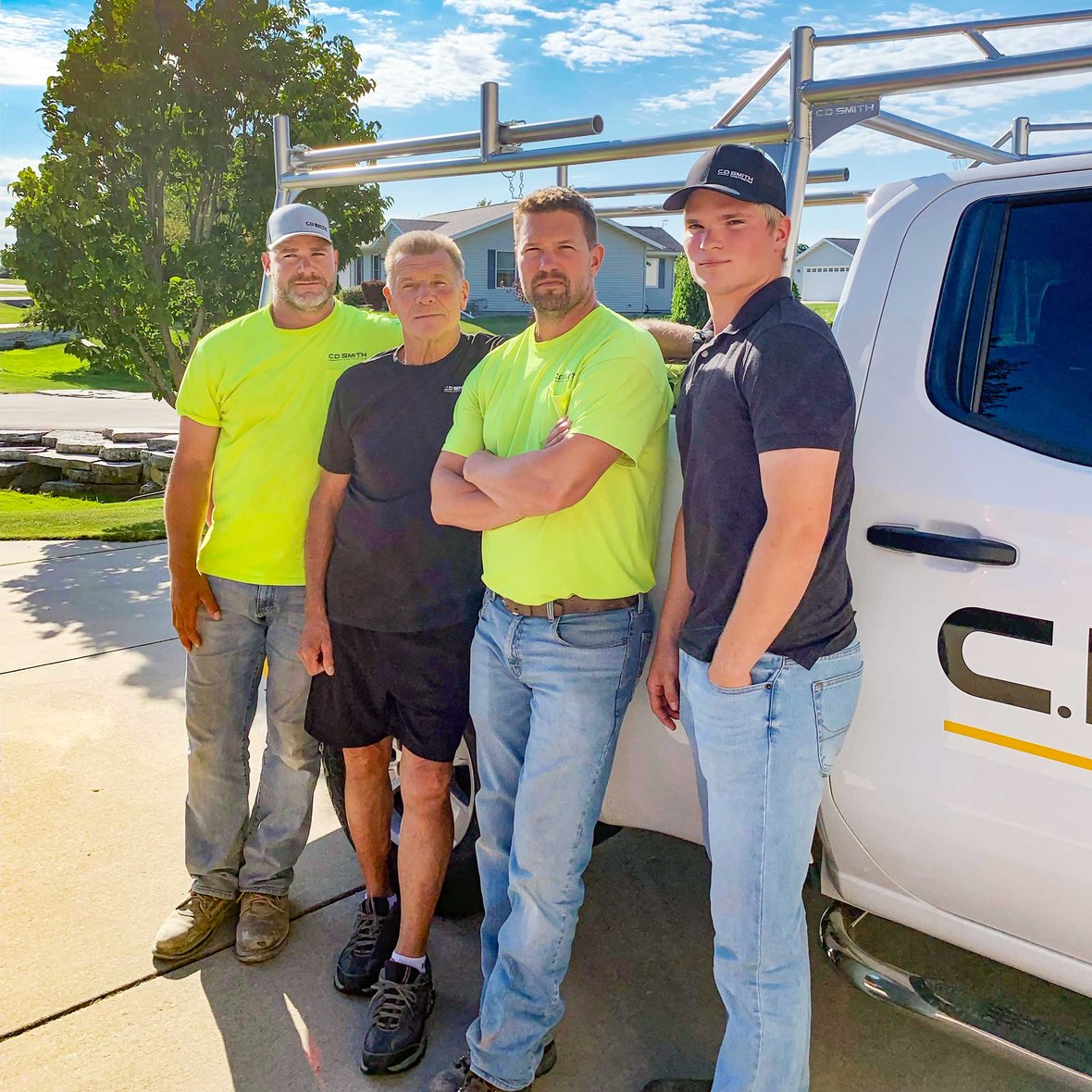 (left to right) Andy, Mike, Matt and Eli Leonard standing in front of a C.D. Smith Construction work truck