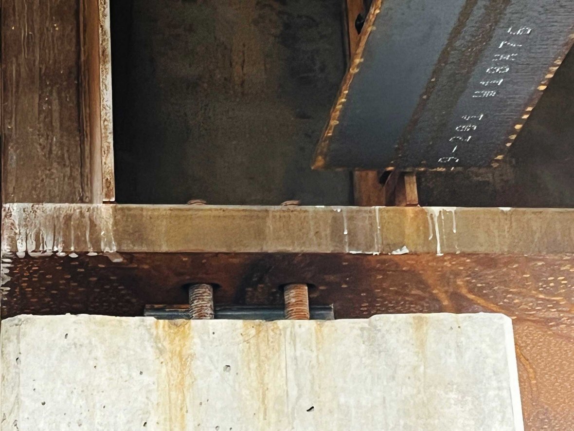 Close-up of steel girder installation for Levy Hall’s main lecture hall, emphasizing beam-to-rod alignment.