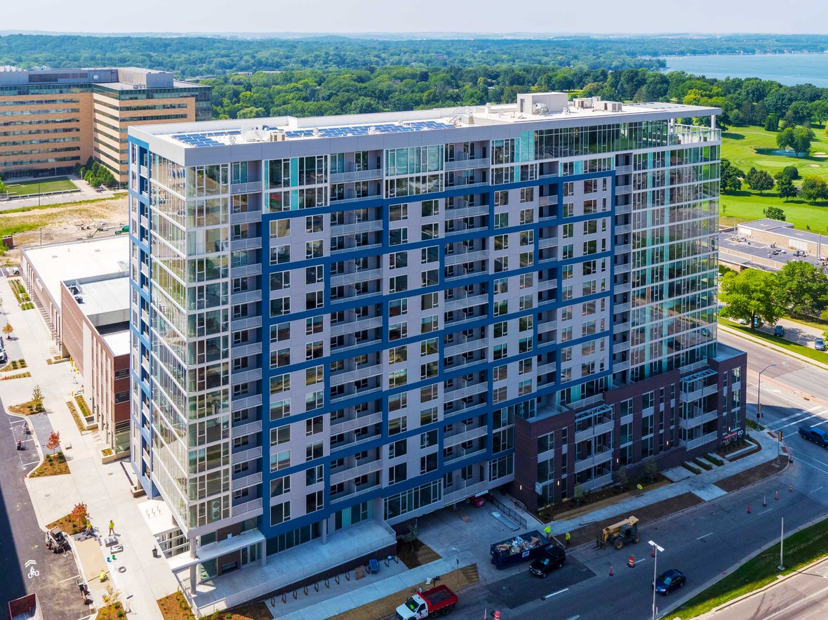 EO Madison Yards Apartments aerial view of high-rise and interior fireplace lobby mixed-use development project building completed by CD Smith Construction