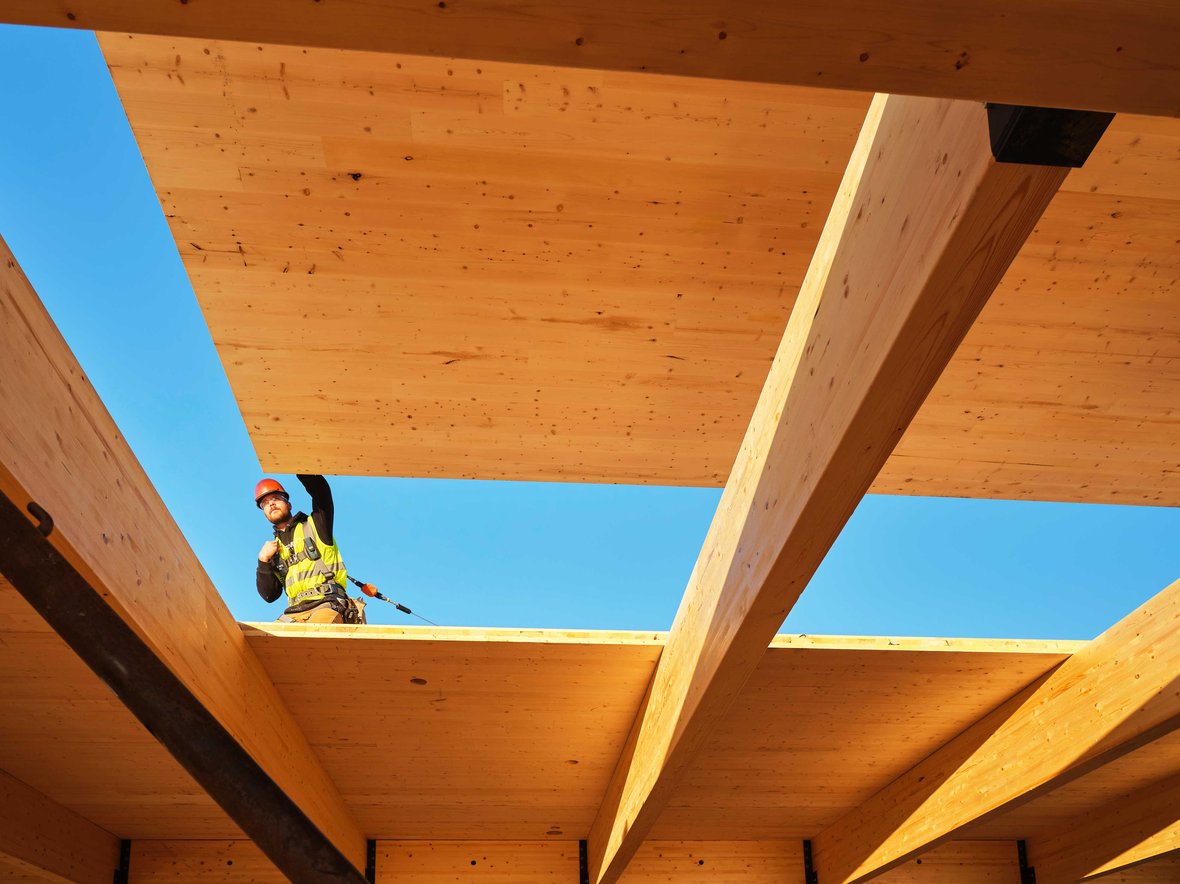 Mass timber building construction of wood panel deck placement on columns and beams for Fastenal Company's new corporate location