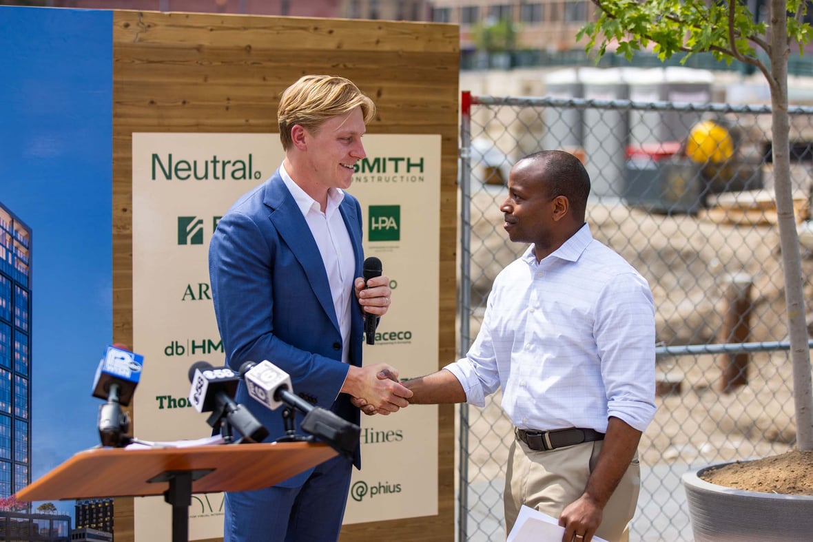 Neutral Nate Helbach greeting Milwaukee Mayor Cavalier Johnson after speaking introduction at Edison mass timber construction groundbreaking
