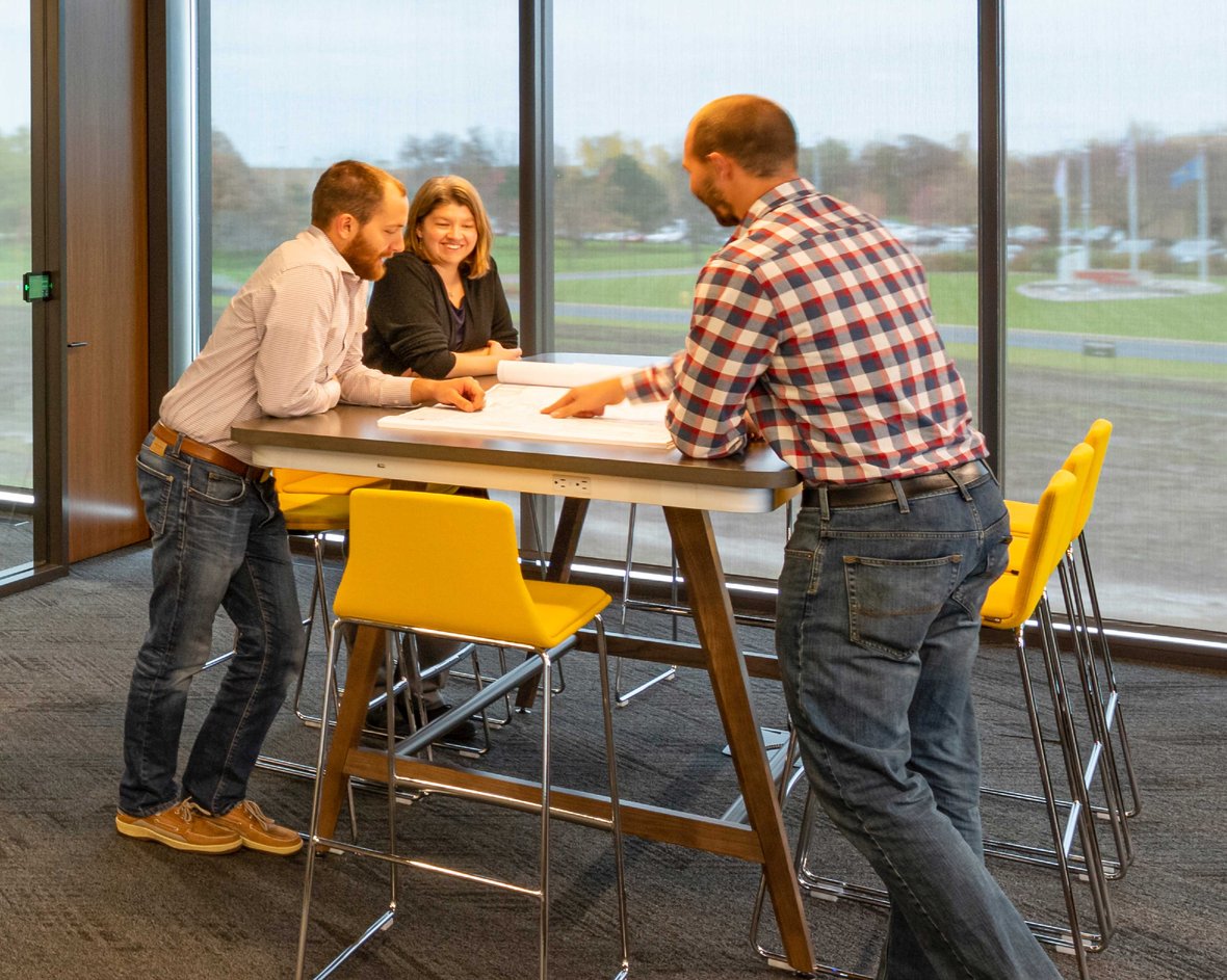 Project Managers standing at table looking over drawing at CD Smith Construction corporate headquarters in Fond du Lac Wisconsin