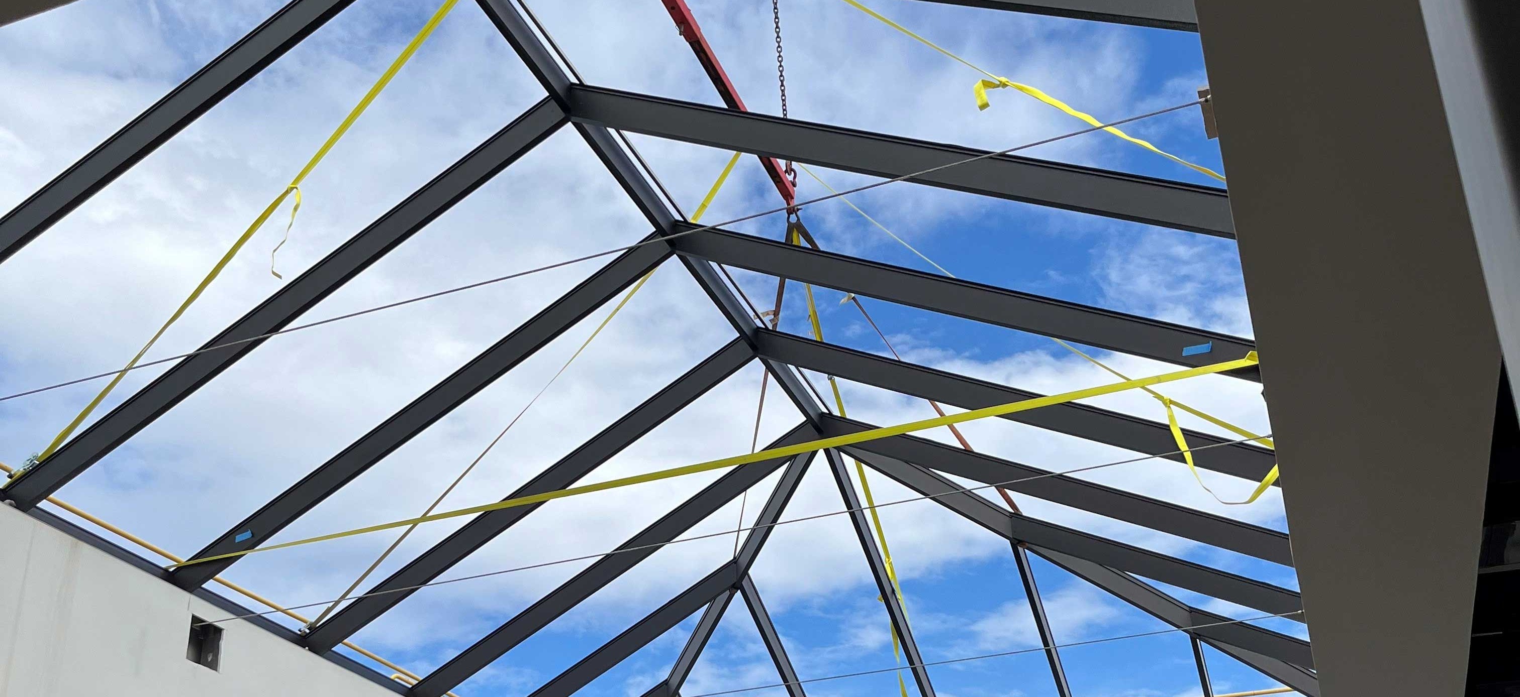 Interior view looking up through the structural steel skylight frame during construction of the Student Collaboration Hub at Sunnyside Elementary School.