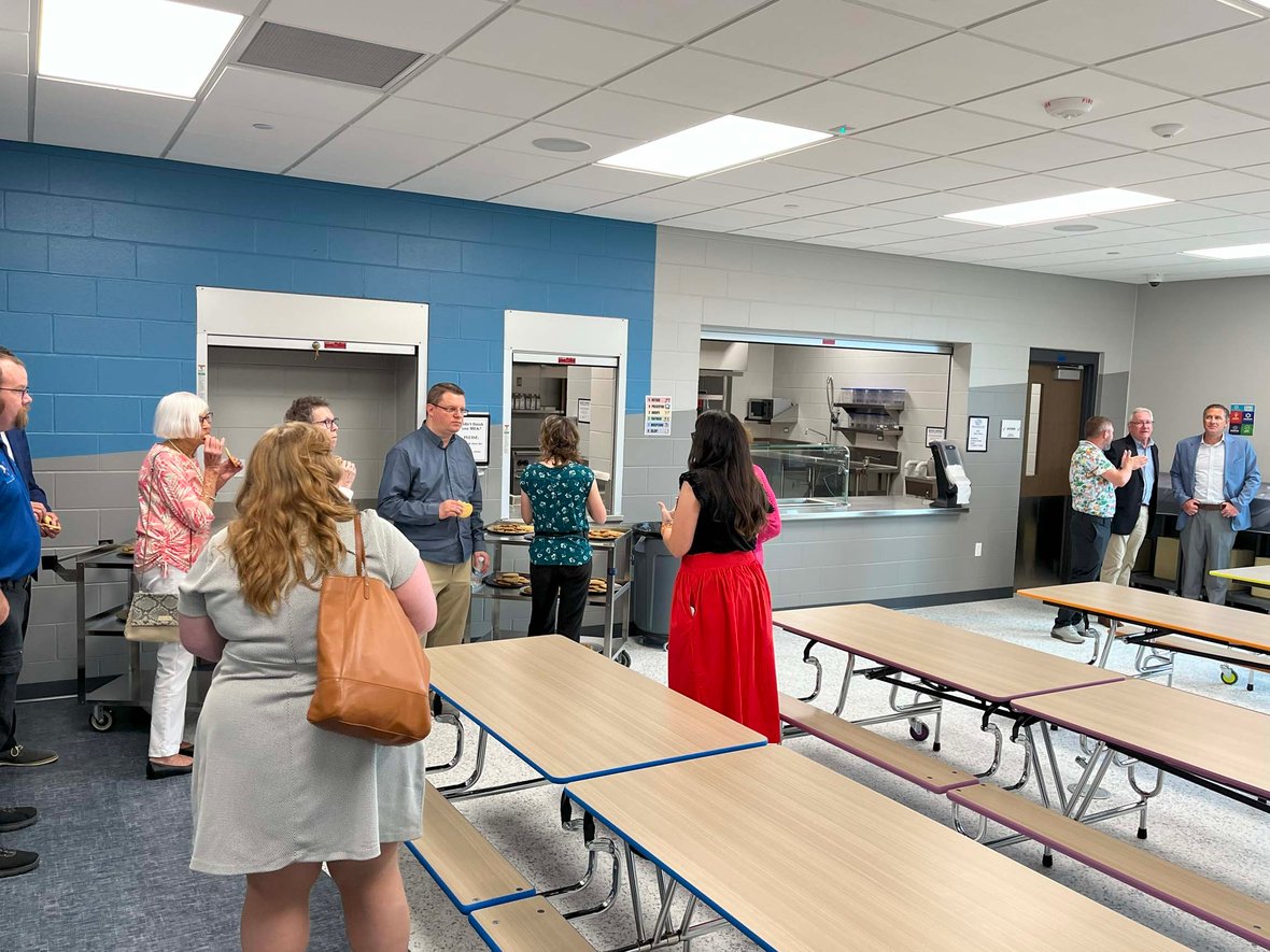 Ribbon-cutting guests tour the newly built kitchen and cafeteria space at the Ripon Boys &amp; Girls Club, enjoying cookies and refreshments in a youth-focused facility delivered through commercial construction services in Wisconsin.