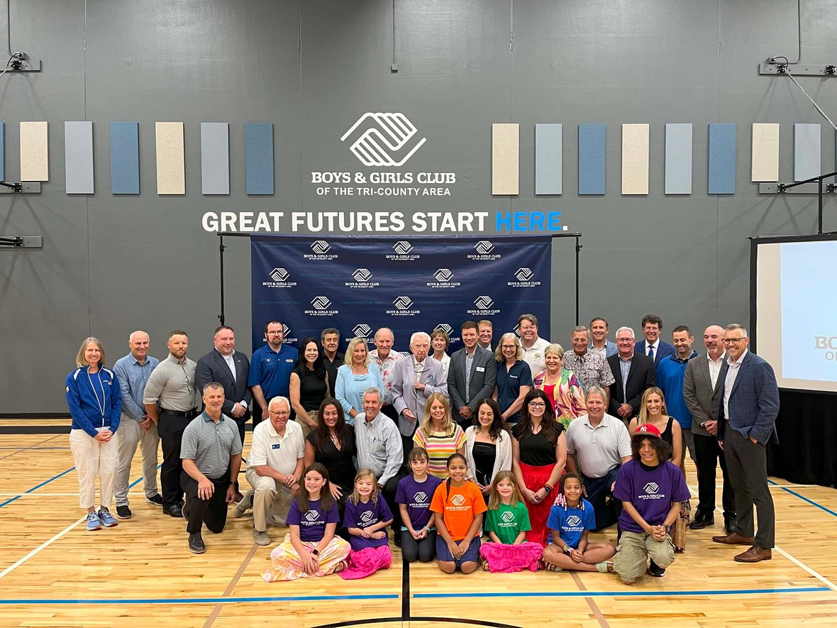 Community leaders, donors, and Boys &amp; Girls Club representatives gather in the Ripon Club gymnasium during the ribbon-cutting ceremony celebrating the opening of a new youth-focused facility built through commercial construction services in Wisconsin.