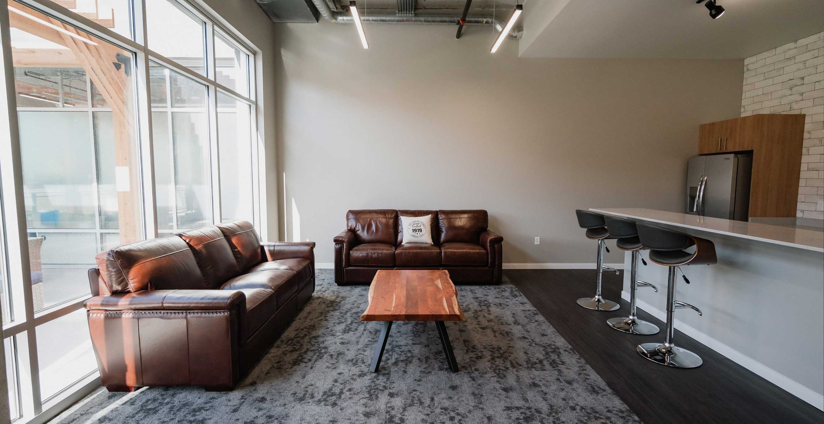 Residential amenity lounge at RiverHeath Willow showcasing fireplace feature wall and open gathering space.