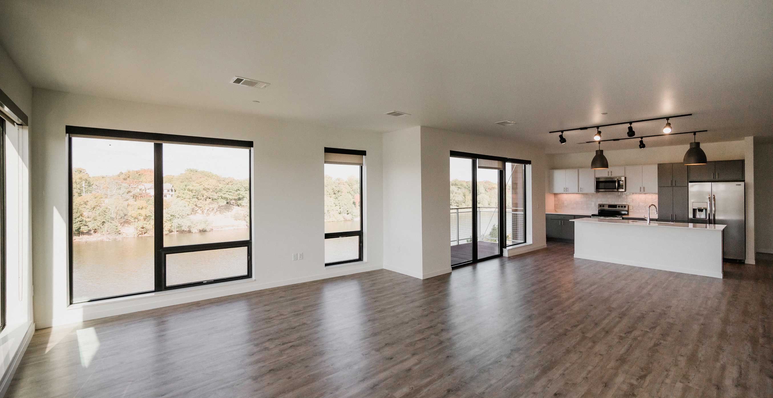 Open living area inside RiverHeath Willow apartment with large windows and river views.