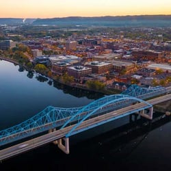 Aerial view of C.D. Smith Construction's La Crosse office, featuring the river, a bridge, and illuminated buildings at night.